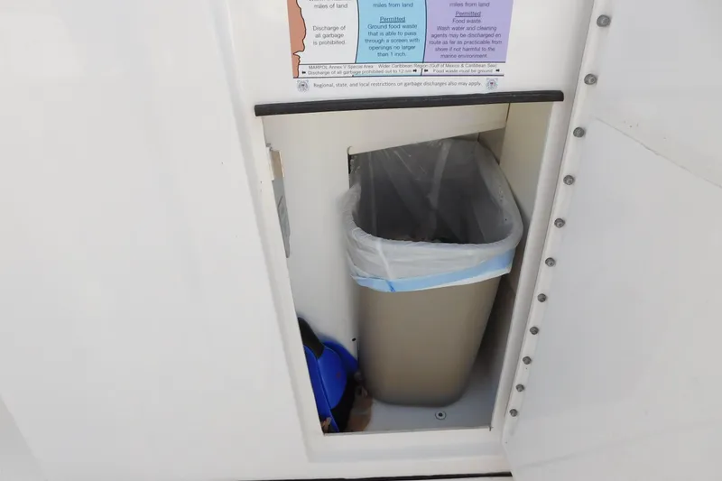 Slide: The Image of Trash bin inside 2024 Pursuit DC 326 Dual Console boat compartment. - 71