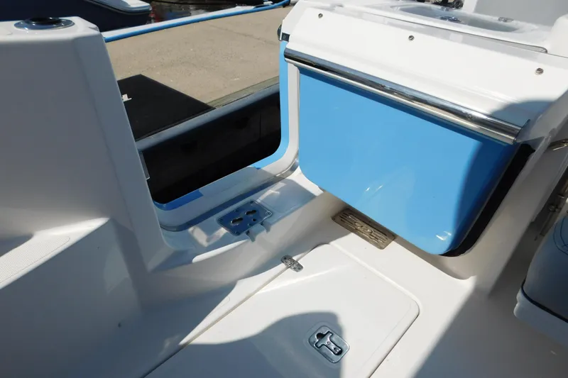 Slide: The Image of 2024 Pursuit DC 326 Dual Console boat interior with blue storage compartment. - 73