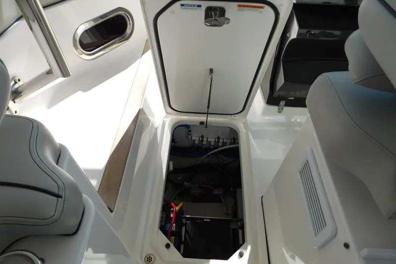 Slide: The Image of 2024 Pursuit DC 326 Dual Console interior storage compartment open, showcasing seating and equipment. - 82