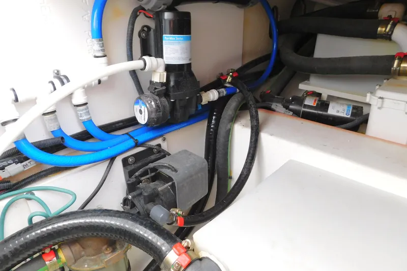 Slide: The Image of 2024 Pursuit DC 326 Dual Console boat engine compartment with hoses and pump system. - 84