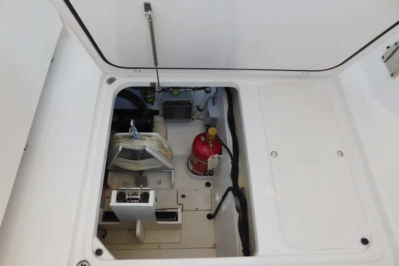 Slide: The Image of 2024 Pursuit DC 326 Dual Console storage compartment with fire extinguisher and equipment. - 88