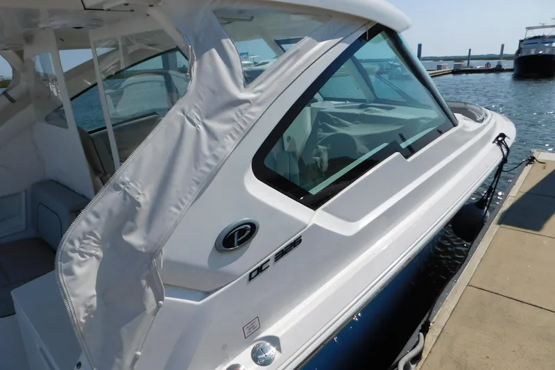 Slide: The Image of 2024 Pursuit DC 326 Dual Console boat docked at marina. - 9