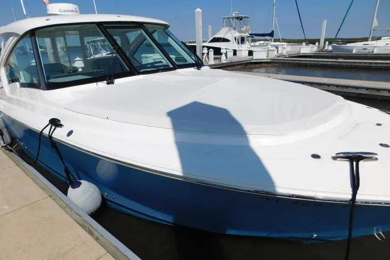 Slide: The Image of 2024 Pursuit DC 326 Dual Console boat docked at marina, featuring sleek design. - 97