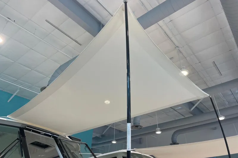 Slide: The Image of 2024 Pursuit DC 326 Dual Console boat with a large sunshade canopy indoors. - 98