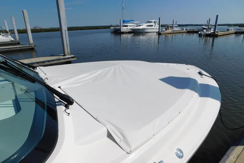 Slide: The Image of 2024 Pursuit DC 326 Dual Console boat docked at marina, covered bow area. - 99