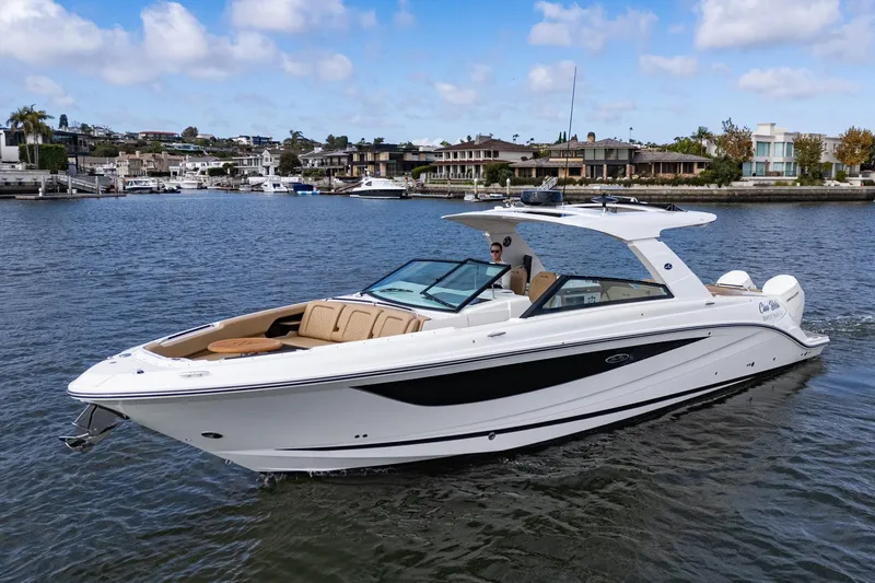 The Image of 2023 Sea Ray SLX 400 Outboard cruising on a scenic waterfront with luxury homes. - 0