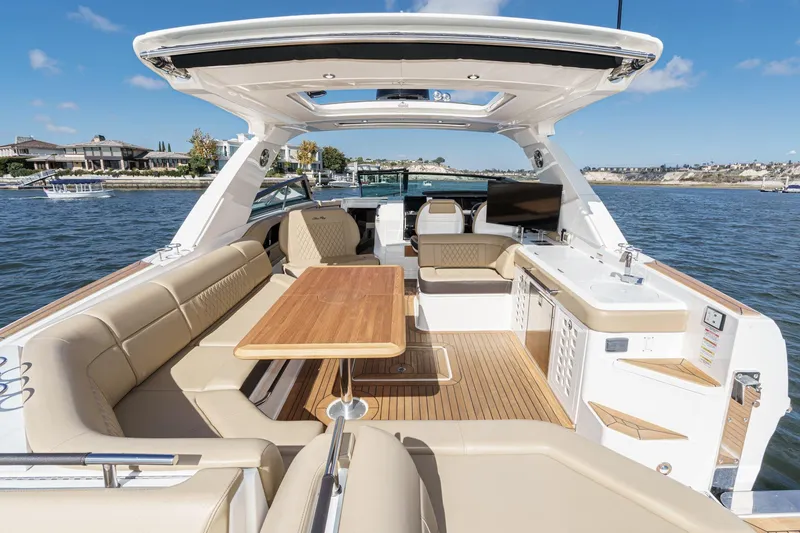 Slide: The Image of 2023 Sea Ray SLX 400 Outboard luxury boat interior with seating and table on water. - 14