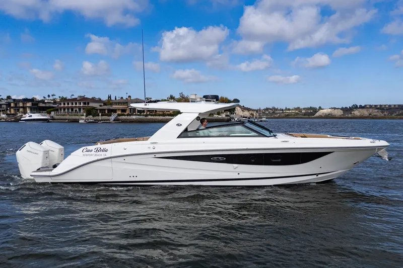 Slide: The Image of 2023 Sea Ray SLX 400 Outboard cruising on water, Newport Beach backdrop. - 2