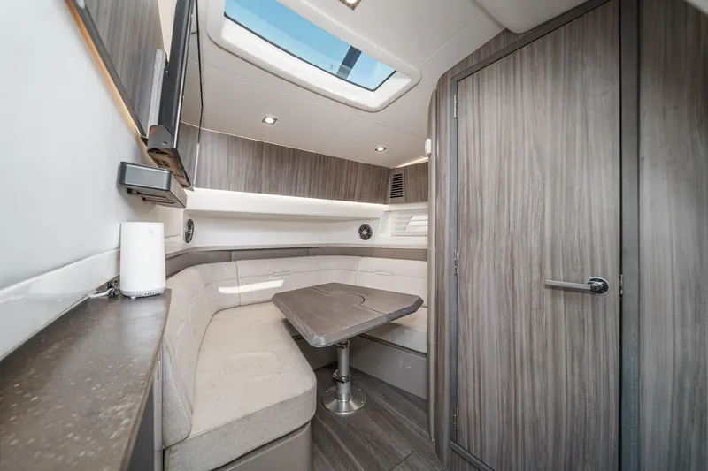 Slide: The Image of 2023 Sea Ray SLX 400 Outboard cabin interior with modern seating and skylight. - 28