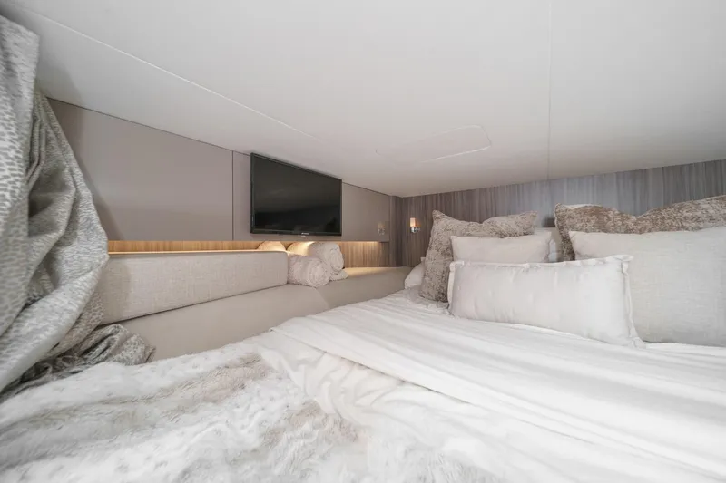 Slide: The Image of Luxurious cabin interior of 2023 Sea Ray SLX 400 Outboard with plush bedding and TV. - 32