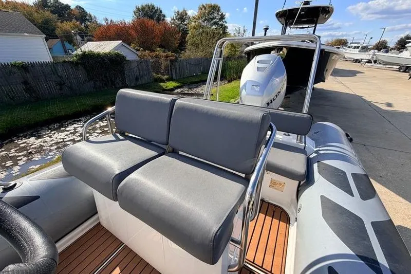 Slide: The Image of 2027 Brig Navigator 610 boat with gray seating and Honda outboard motor. - 7