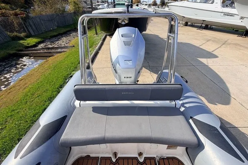 Slide: The Image of 2027 Brig Navigator 610 boat with 135 HP engine, docked on a sunny day. - 8