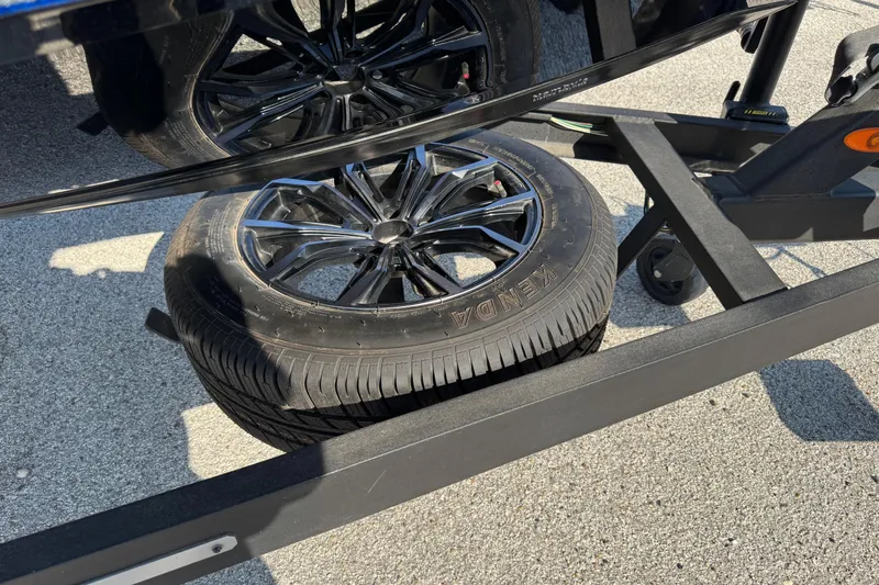 Slide: The Image of 2023 Vexus VX20 trailer with Kenda spare tire on pavement. - 2
