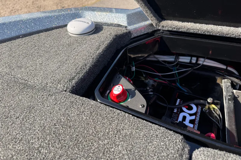 Slide: The Image of 2023 Vexus VX20 boat battery compartment with wiring and red switch. - 23