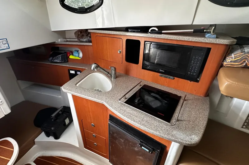 Slide: The Image of Compact kitchen area in a 2008 Sailfish 3006 boat with sink, microwave, and stove. - 17