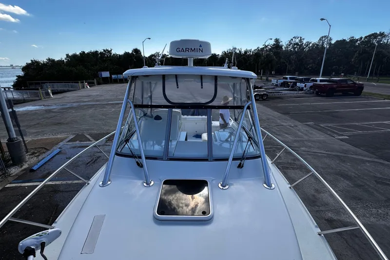 Slide: The Image of 2008 Sailfish 3006 boat at dock with Garmin equipment, clear sky, and parking lot view. - 21