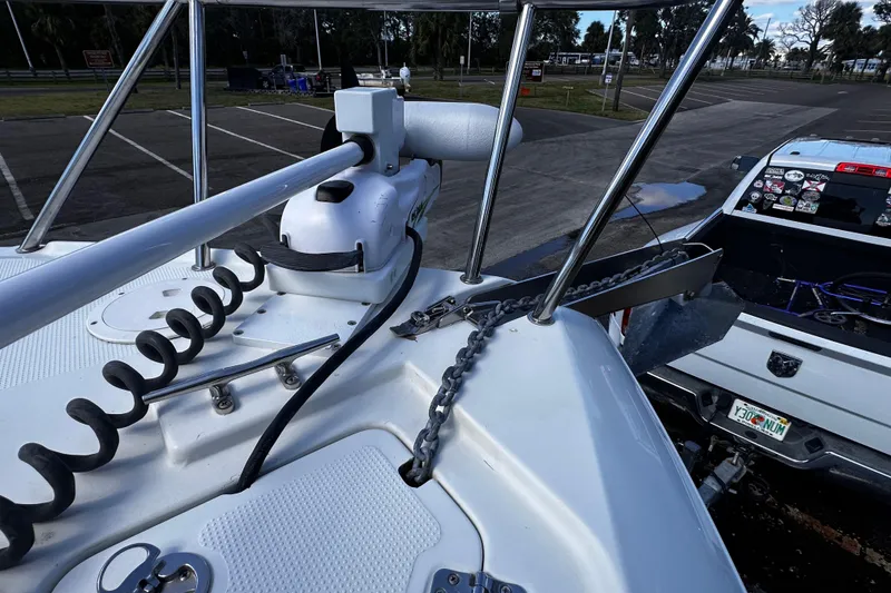 Slide: The Image of Bow of a 2008 Sailfish 3006 boat with anchor chain and motor, parked near a truck. - 18