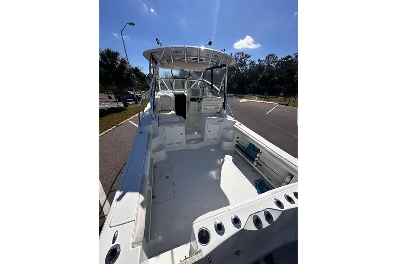 Slide: The Image of 2008 Sailfish 3006 boat interior with seating and storage, parked outdoors under clear sky. - 7