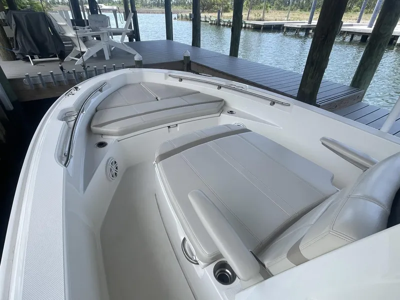 Slide: The Image of 2022 Boston Whaler 220 Dauntless boat interior with seating and storage features. - 17