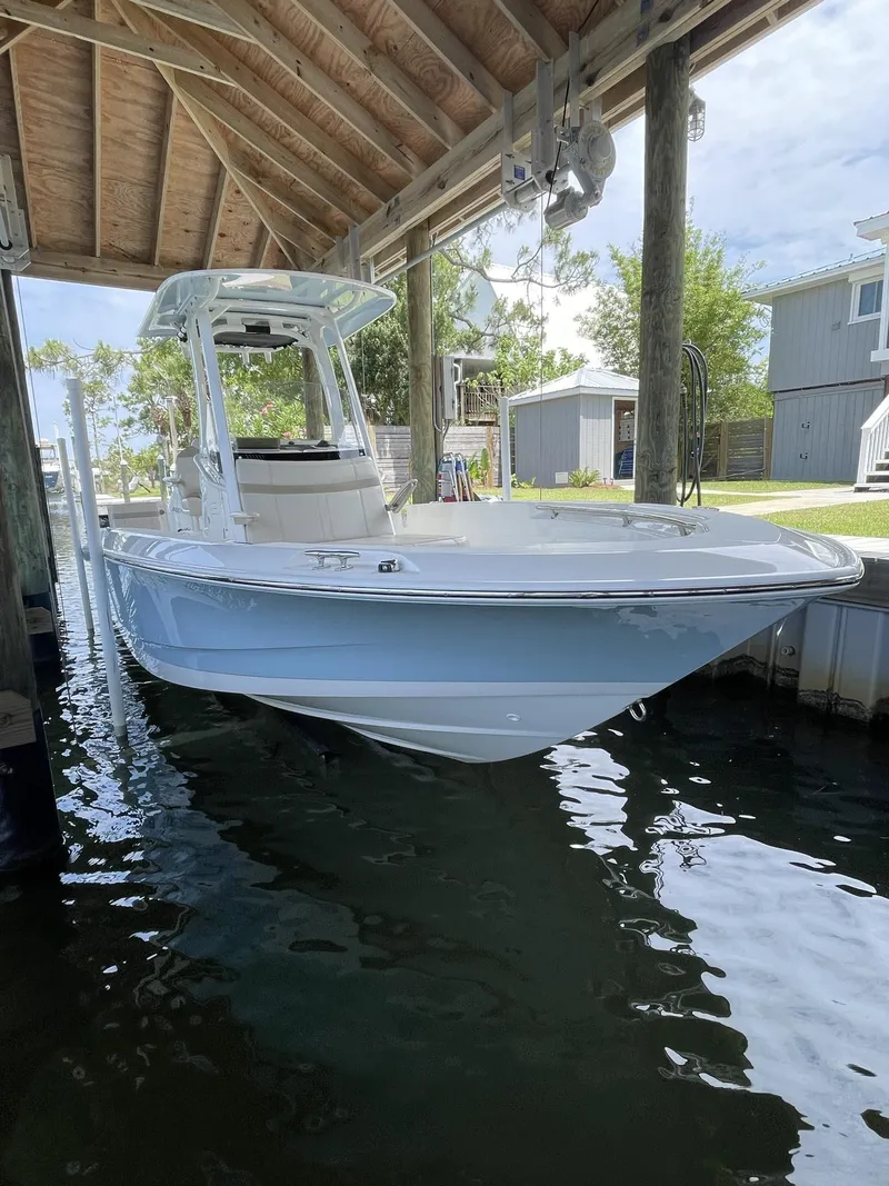 Slide: The Image of 2022 Boston Whaler 220 Dauntless boat on trailer, rear view, cloudy sky background. - 4