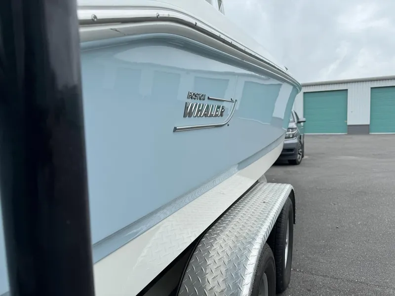 Slide: The Image of 2022 Boston Whaler 220 Dauntless boat with Mercury engine in a covered dock. - 7
