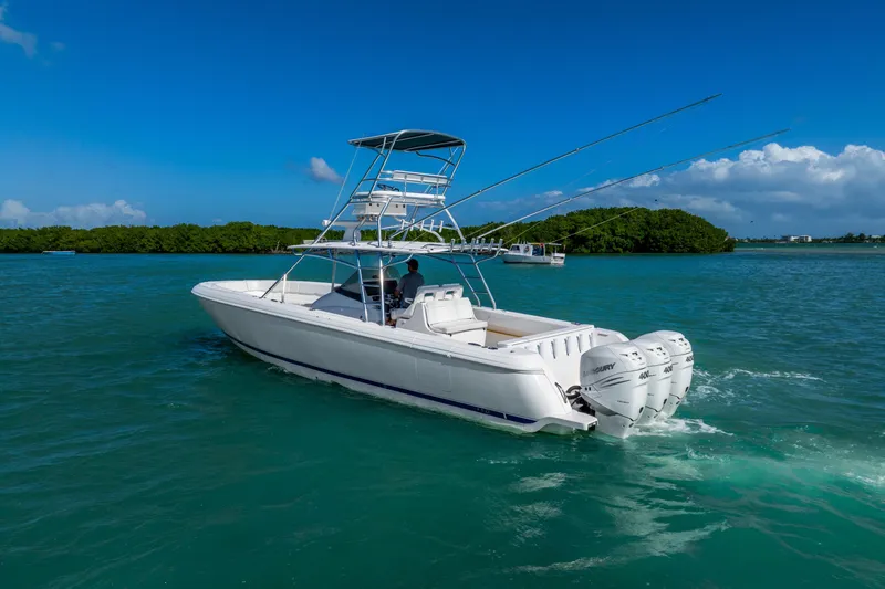 Slide: The Image of 2016 Intrepid 400 Center Console boat cruising on turquoise waters near lush islands. - 12