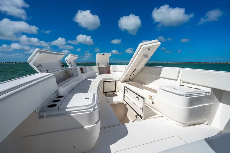 Slide: The Image of 2016 Intrepid 400 Center Console boat interior with open storage compartments under a clear blue sky. - 32