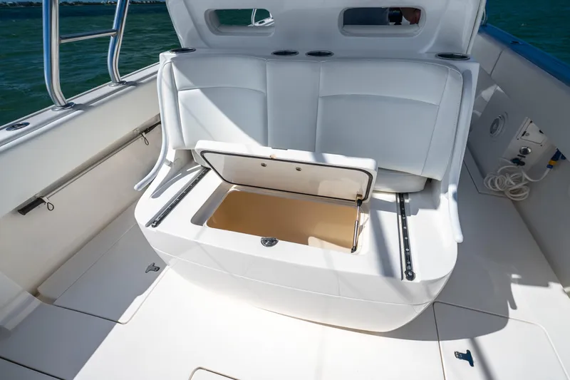 Slide: The Image of 2016 Intrepid 400 Center Console boat with open storage compartment, white seating, and ocean backdrop. - 40