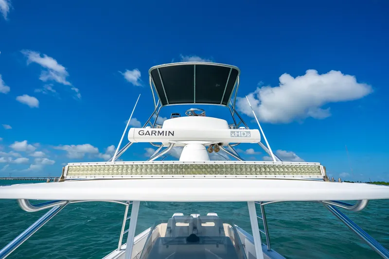 Slide: The Image of 2016 Intrepid 400 Center Console boat with sleek blue canopy against clear sky. - 45