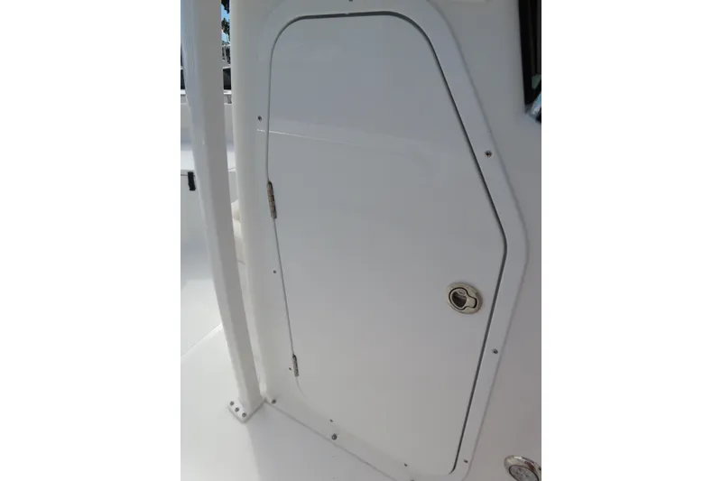 Slide: The Image of 2025 Sea Hunt Ultra 229 boat compartment door, white with metal handle. - 19