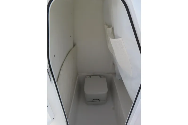 Slide: The Image of Interior of 2025 Sea Hunt Ultra 229 boat, featuring compact marine toilet. - 20