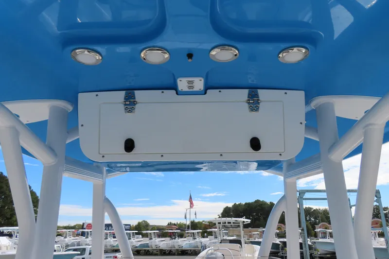 Slide: The Image of 2025 Sea Hunt Ultra 229 boat interior with blue canopy and storage compartment. - 26