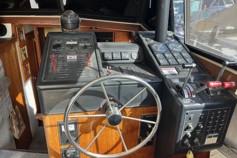 Slide: The Image of 1989 Bayliner 3888 MY Sedan helm with steering wheel and control panels. - 12