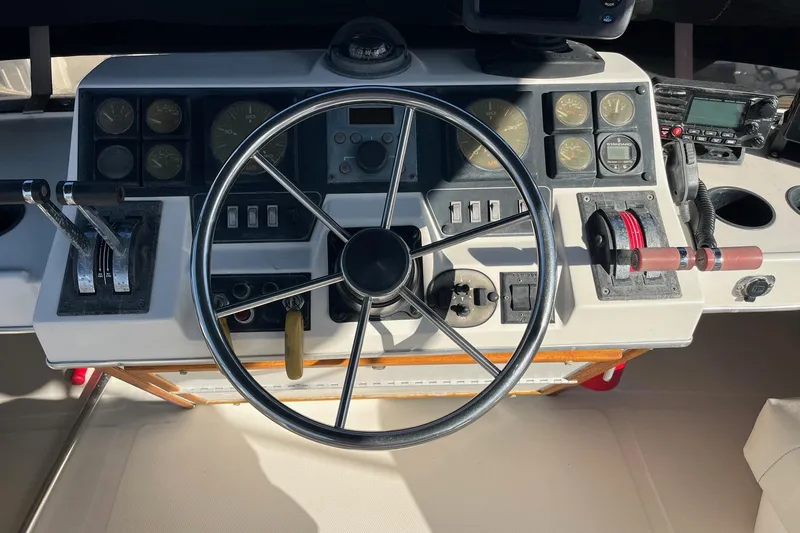 Slide: The Image of 1989 Bayliner 3888 MY Sedan helm with steering wheel and control panel. - 14