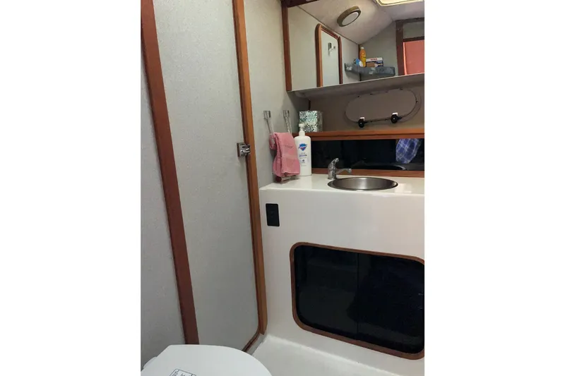 Slide: The Image of 1989 Bayliner 3888 MY Sedan bathroom with sink, mirror, and toiletries. - 15