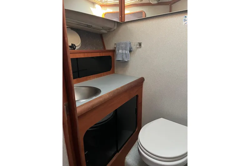 Slide: The Image of 1989 Bayliner 3888 MY Sedan bathroom with sink, toilet, and wooden cabinetry. - 16