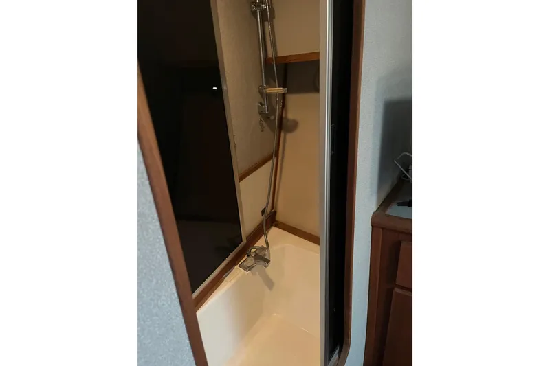 Slide: The Image of Shower area inside 1989 Bayliner 3888 MY Sedan boat, featuring a handheld showerhead. - 17