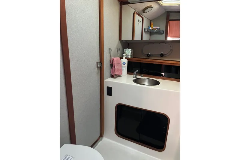 Slide: The Image of 1989 Bayliner 3888 MY Sedan bathroom with sink, mirror, and storage. - 20