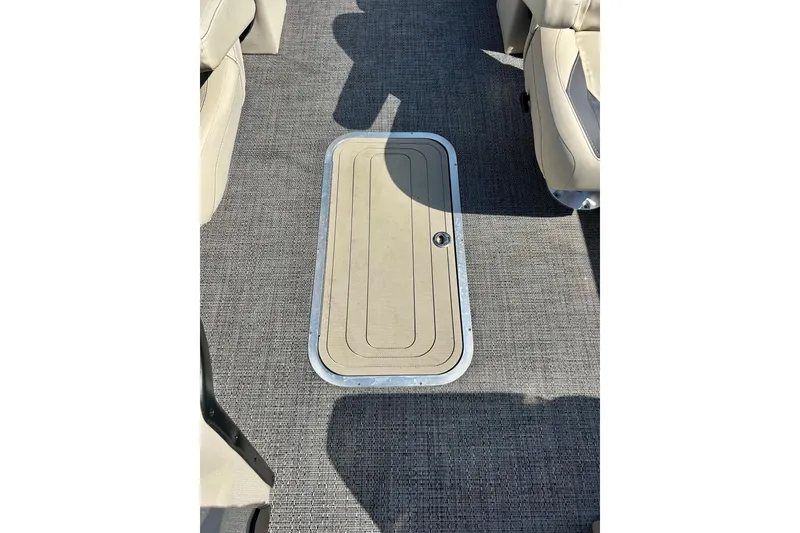 Slide: The Image of 2024 Barletta ARIA 22QC boat interior with carpeted floor and storage hatch. - 24