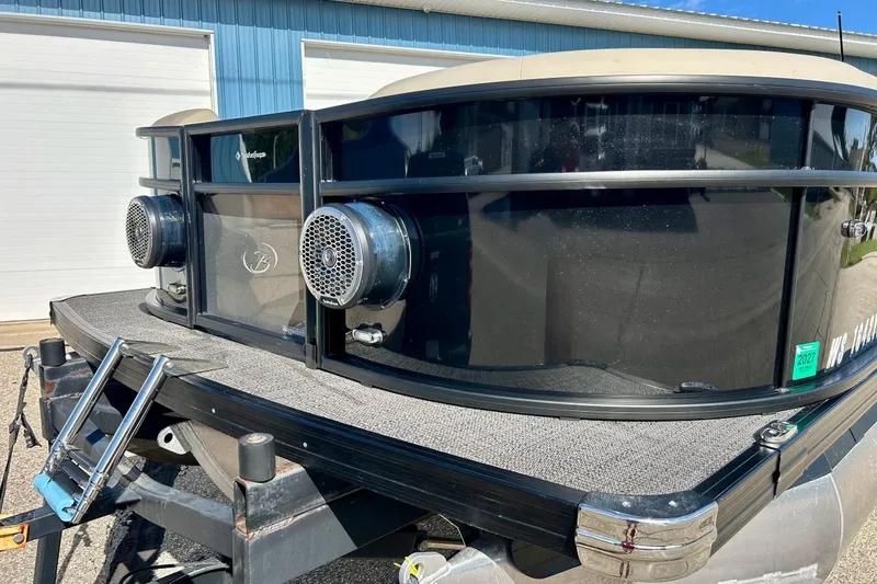 Slide: The Image of 2024 Barletta ARIA 22QC pontoon boat with speakers and ladder, parked outdoors. - 66