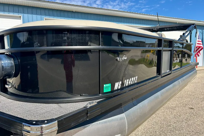 Slide: The Image of 2024 Barletta ARIA 22QC pontoon boat with sleek black exterior, docked outdoors. - 67