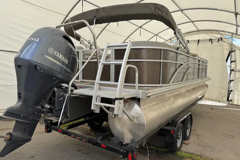 Slide: The Image of 2023 Bennington 23SSR pontoon boat with Yamaha 150 engine in covered storage. - 3