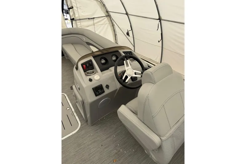 Slide: The Image of 2023 Bennington 23SSR boat interior with steering wheel and seating in a covered area. - 6