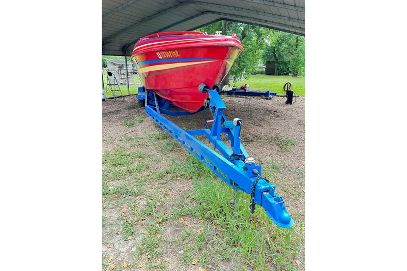 Slide: The Image of 1987 Chris-Craft 312 Stinger boat on blue trailer under shelter. - 11