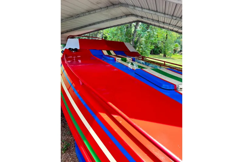 Slide: The Image of Colorful 1987 Chris-Craft 312 Stinger boat under a metal canopy. - 13