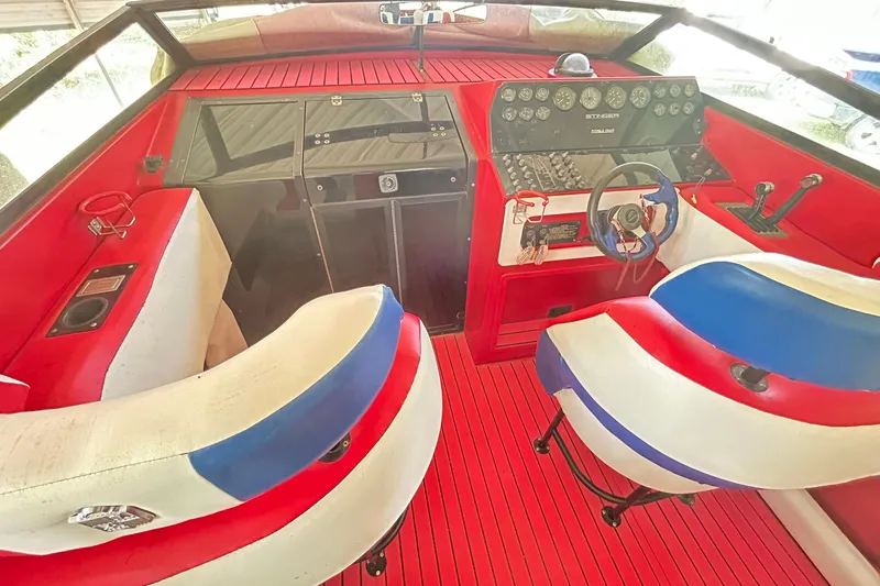 Slide: The Image of 1987 Chris-Craft 312 Stinger boat interior with red, white, and blue seating and dashboard. - 2