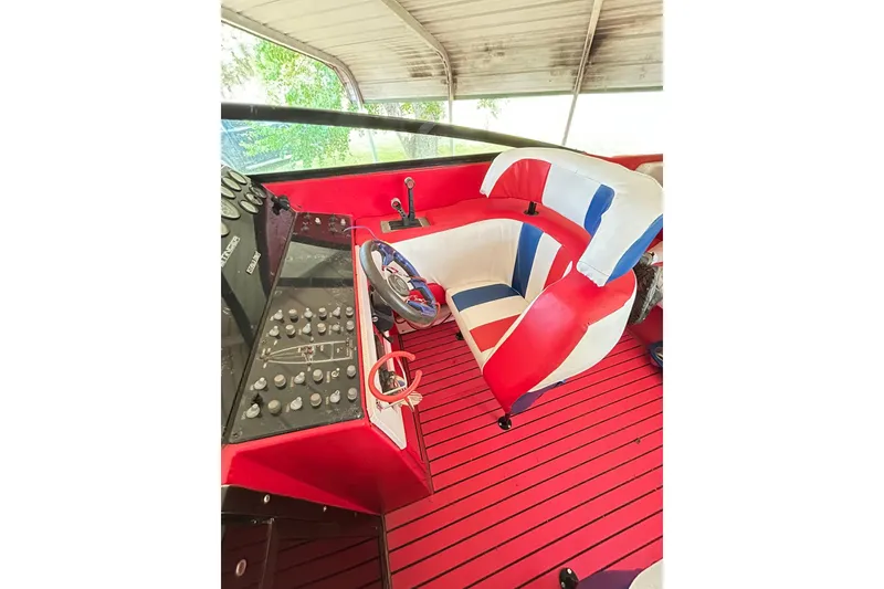 Slide: The Image of 1987 Chris-Craft 312 Stinger cockpit with red, white, and blue seating and control panel. - 26