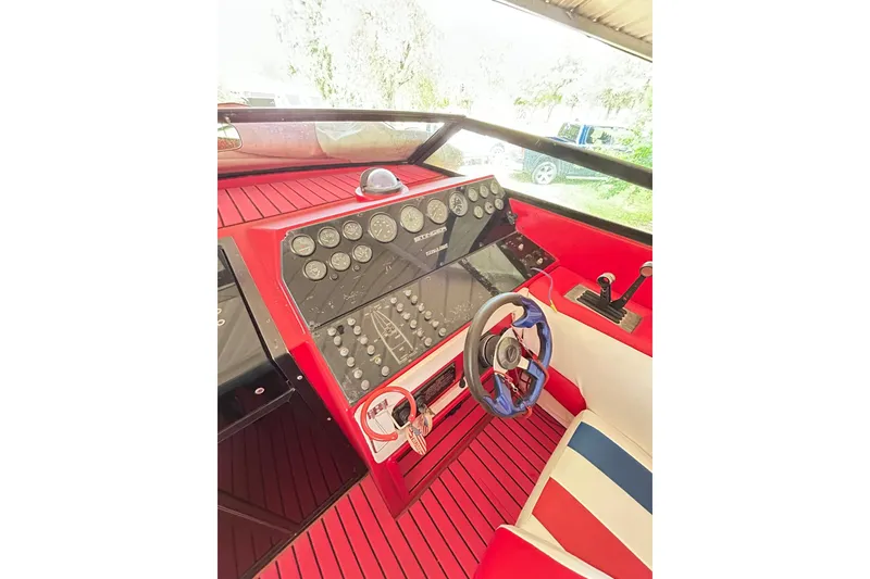 Slide: The Image of 1987 Chris-Craft 312 Stinger boat dashboard with red accents and steering wheel. - 27
