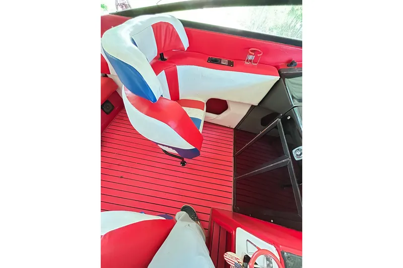 Slide: The Image of 1987 Chris-Craft 312 Stinger interior with red, white, and blue seating and striped flooring. - 29