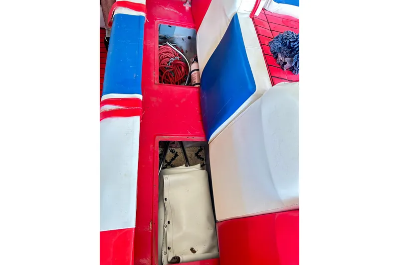 Slide: The Image of 1987 Chris-Craft 312 Stinger interior with red, white, and blue seating and storage compartments. - 31